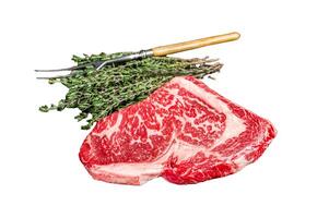 Black Angus Rib Eye steak, raw marbled beef meat with herbs. Dark background. Top view photo