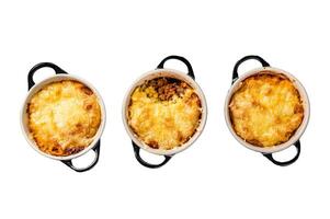 Homemade shepherd's pie with ground meat, mashed potato and cheddar cheese crust. Isolated on white background, top view. photo