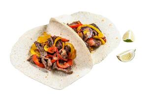 Fajitas with beef meat stripes, colored bell pepper and onions, served with tortillas and salsa. Isolated on white background. photo