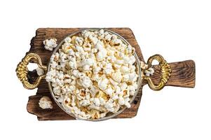 Prepared salty popcorn in a skillet and corn kernel. Isolated, white background. photo