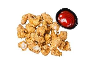 Crispy Fried breadcrumb covered chicken popcorn with ketchup. Isolated, white background. photo