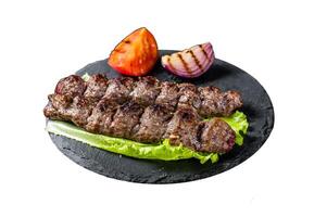 Grilled Urfa kebab with tomato, salad and onion. Isolated on white background. Top view. photo