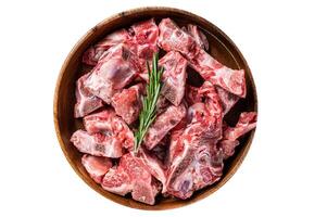 Fresh Raw meat on the bone diced for goulash in a wooden plate. High quality Isolate, white background. photo