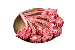 Lamb chop rib steak, raw mutton meat cutlet in golden plate. Isolated on white background. Top view. photo