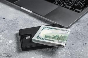 Workplace with stylish leather wallet with money, Laptop. Gray background. Top view. Copy space photo