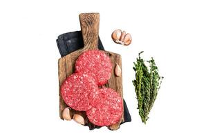Raw veal hamburger patties with herbs and spices. Isolated on white background, top view. photo