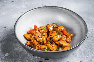 Chinese Sweet and Sour Pork guo bao rou in a bowl. Gray background. Top view photo