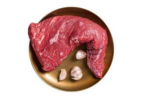 Raw tri-tip triangle roast or bottom sirloin steak on plate with herbs. Isolated on white background. photo