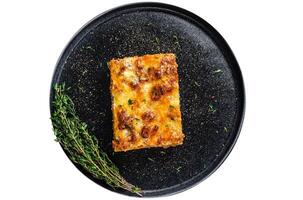 Lasagna with mince beef meat and tomato bolognese sauce on a plate. Isolated on white background. photo
