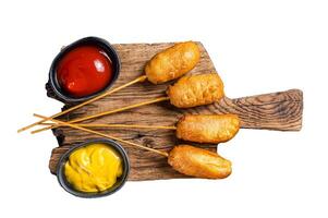 Traditional American street junk food Deep fried corn dogs with mustard and ketchup. Isolated, white background. photo