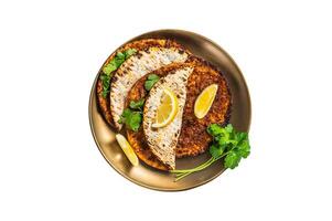 Turkish lahmacun pizza with mince meat and tomatoes on a plate with parsley and lemon. Isolated on white background. photo