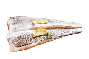 Fresh raw hake fish fillet with pepper and lemon. Isolated on white background. Top view. photo