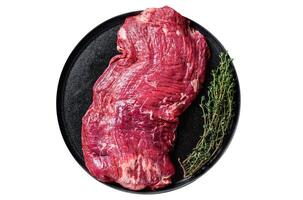 Flank or flap raw beef steak on plate with thyme. Isolated, white background. Top view. photo