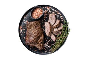 Barbecue dry aged wagyu Tri Tip beef steak on a plate with pink salt. Isolated on white background. photo