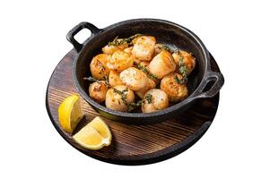 Scallops seared in garlic, thyme and butter served in cast iron skillet. Isolated on white background. Top view. photo