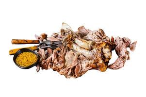 Roast pork knuckle eisbein meat on a baking pan with herbs. Isolated on white background. photo