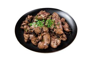 Fried chicken liver with onions and parsley in a plate. Isolated on white background. Top view. photo