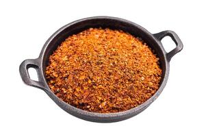 Red Chili pepper and paprika flakes in a skillet isolated on white background. top view photo
