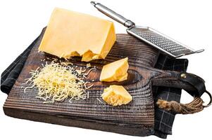 Grated cheddar cheese piece on a wooden board. Isolated on white background, top view. photo