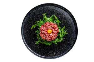 Beef tartare with arugula and quail egg. Isolated on white background. photo