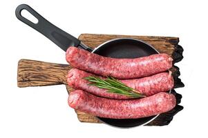 Raw sausages ready for cooking in a skillet, uncooked meat. Isolated, white background. photo