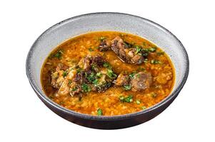 Kharcho beef meat soup with rice, tomatoes and spices in a bowl. Isolated on white background, top view. photo