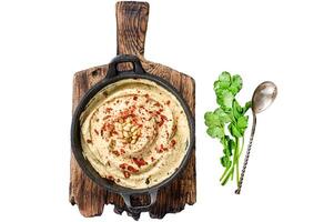 Hummus paste with chickpea and parsley in a bowl. Isolated on white background, top view. photo