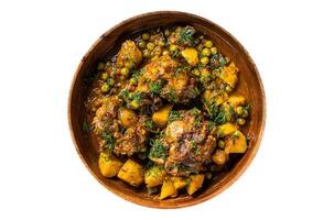 Lamb oxtails tails stew with vegetables in a wooden plate. Isolated, white background. Top view. photo
