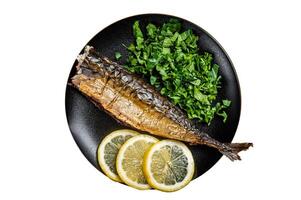 Grilled Mackerel Scomber fish on a plate with greens and lemon. Isolated on white background. photo