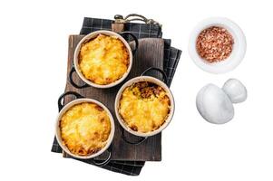 British dish Shepherd's pie with ground meat, mashed potato and cheddar cheese crust. Isolated on white background, top view. photo