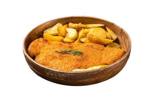 Austrian fried weiner schnitzel with potato wedges in a wooden plate. Isolated on white background. Top view. photo