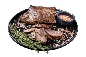 Barbecue dry aged wagyu Tri Tip beef steak on a plate with pink salt. Isolated on white background. Top view. photo