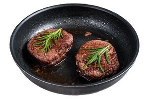 Grilled Fillet Mignon tenderloin meat beef steaks in pan. Isolated on white background, top view. photo