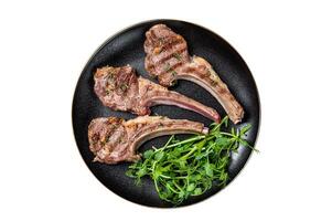Roasted lamb meat cutlets, mutton chops with garnish. Isolated on white background. photo