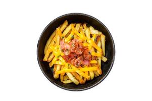 French fries with melted mix of cheddar cheese and bacon served in a pan. Isolated, white background. photo
