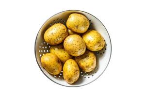 Raw washed potatoes in a colander. Isolate, white background. photo