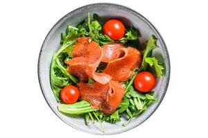 Salad with smoked salmon, arugula, avocado and cherry tomatoes. Concept for a tasty and healthy meal. Isolated on white background. photo