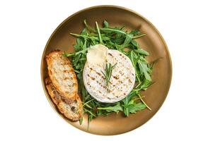 Salad with grilled Camembert cheese, arugula, toast and rosemary in a plate. Isolated on white background. photo
