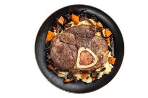 Osso buco cross cut veal shank with mashed potato on a plate. Isolated on white background. photo