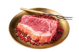 Raw Wagyu striploin, New york steak on a plate with pink peppper. Isolated on white background. Top view.view photo