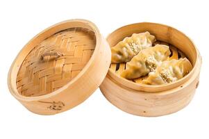 Steamed Japanese Gyoza Dumplings with pork meat and vegetables in bamboo steamer isolated on white background. top view photo
