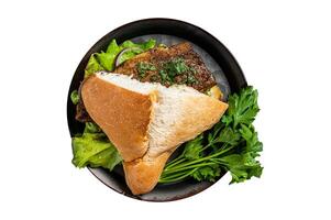 Sandwich balik Ekmek with grilled fillet of mackerel fish, tomatoes, onions and lettuce. Isolated on white background. photo