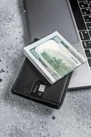 Workplace with stylish leather wallet with money, Laptop. Gray background. Top view. Copy space photo