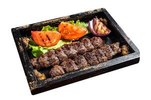 Traditional middle east kefta or kofta kebab, ground beef and lamb meat grilled on skewers served with tomato, salad and onion. Isolated on white background. Top view. photo
