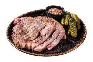 Grilled meat - Pork steaks from neck fillet meat in plate with pickled cucumbers. Isolated on white background. photo
