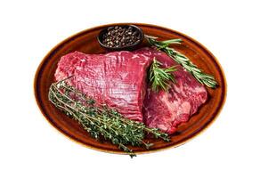 Two Flap or Flank raw beef steaks on a rustic plate with herbs. Isolated on white background. photo