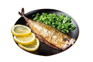 Grilled Mackerel Scomber fish on a plate with greens and lemon Isolated on white background. Top view. photo