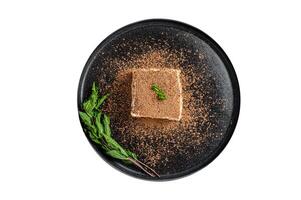 Italian Tiramisu cake with cocoa and mint on a plate. Isolated on white background. photo