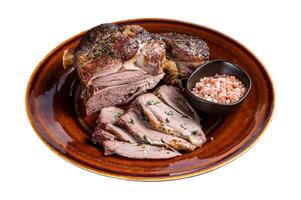 BBQ Roast Lamb mutton leg sliced on a rustic plate. Isolated on white background. Top view. photo