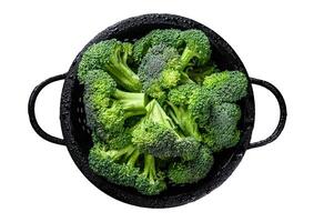 Organic Raw green broccoli cabbage in a colander. Isolated on white background. Top view. photo